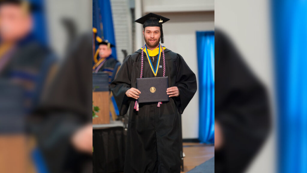 Aiden Hulings, a computer information systems and technology graduate of the University of Pittsburgh at Bradford, walks during the spring commencement ceremony last month. Hulings, a member of the U.S. Air Force Reserve, finished his final semester at Pitt-Bradford while deployed to the Middle East thanks to the help of his professors.