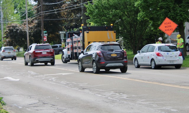 Construction workers put up signage Monday morning for the East State Street construction that is part of Walkable Olean III and includes a mini roundabout at Barry Street. (Rick Miller/Olean Star)
