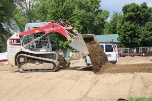 (Rick Miller/Olean Star)An employee of Grindline Skateparks of Washington State spreads soil at the site of the new Allegany Skate Park, now under construction at Allegany River Park on Union Street in Allegany. The park should be ready in August or September.
