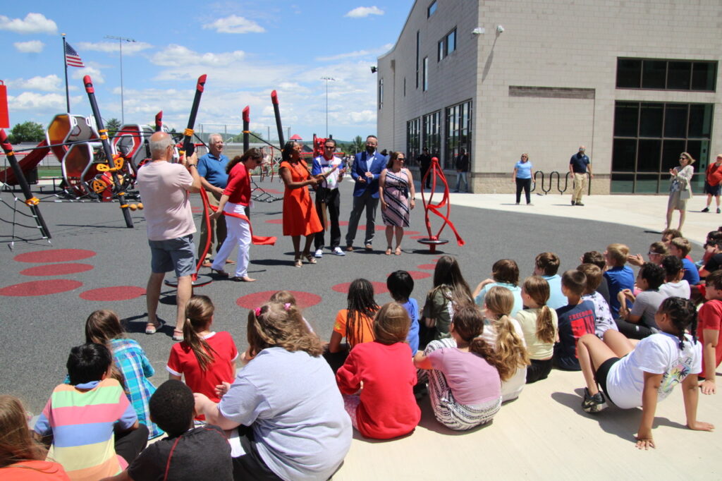 (Rick Miller/Olean Star) Olean Intermediate Middle School students and district officials listen during the ribbon-cutting ceremony for the new $30 million turf field and playground on Wayne Street Friday.