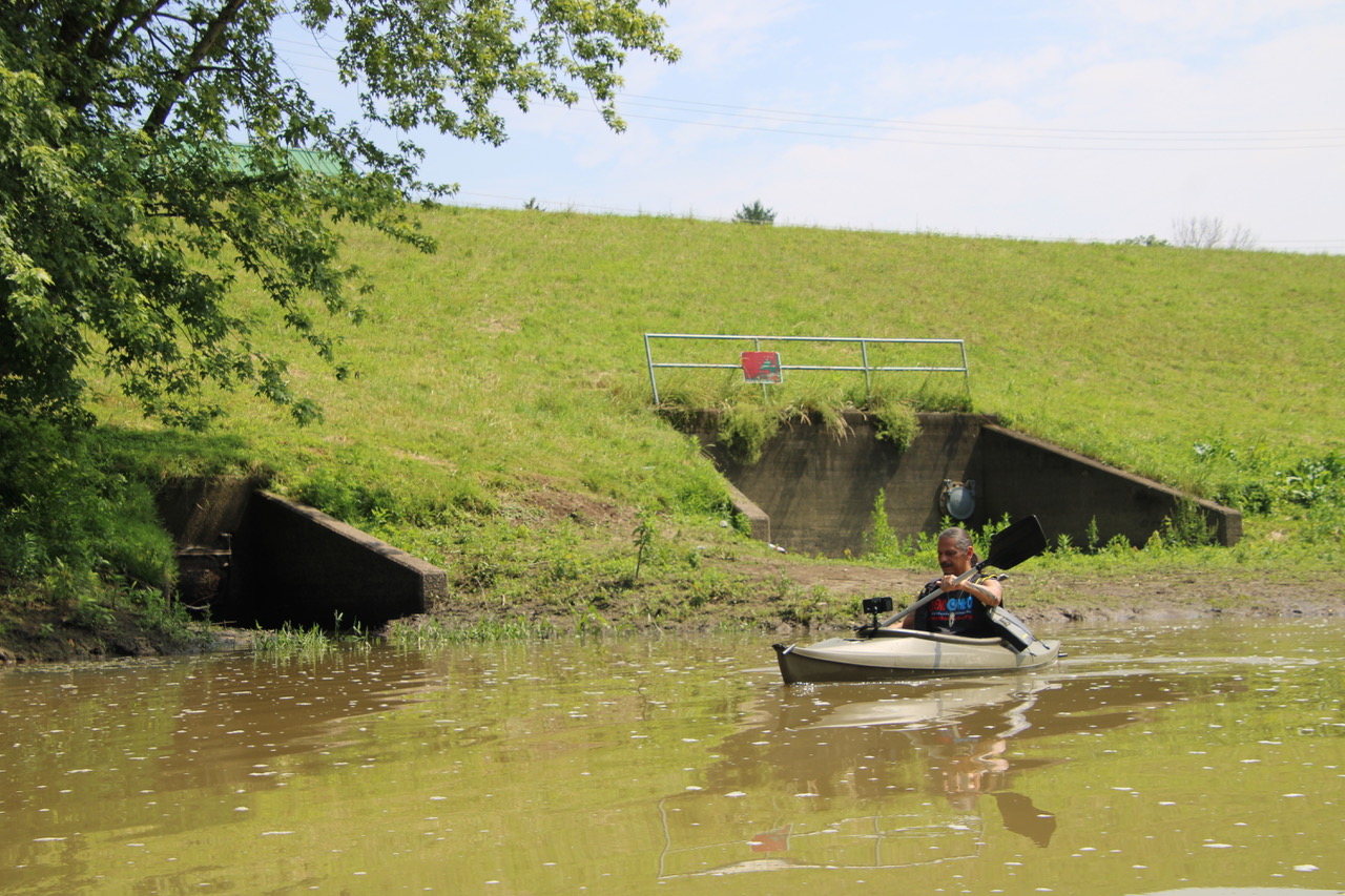 (Rick Miller/Olean Star) Degaweno:da’s, a Seneca activist, kayaks past the Fourth Street pumping station outflow on the Allegheny River on Thursday. The night before, 200,000 gallons of untreated sewage overflowed from the station into the river.