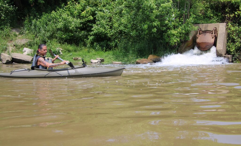 (Rick Miller/Olean Star)  Degaweno:da’s, a Seneca activist, paddles near the discharge of treated sewage at the Olean wastewater treatment plant on Thursday.  