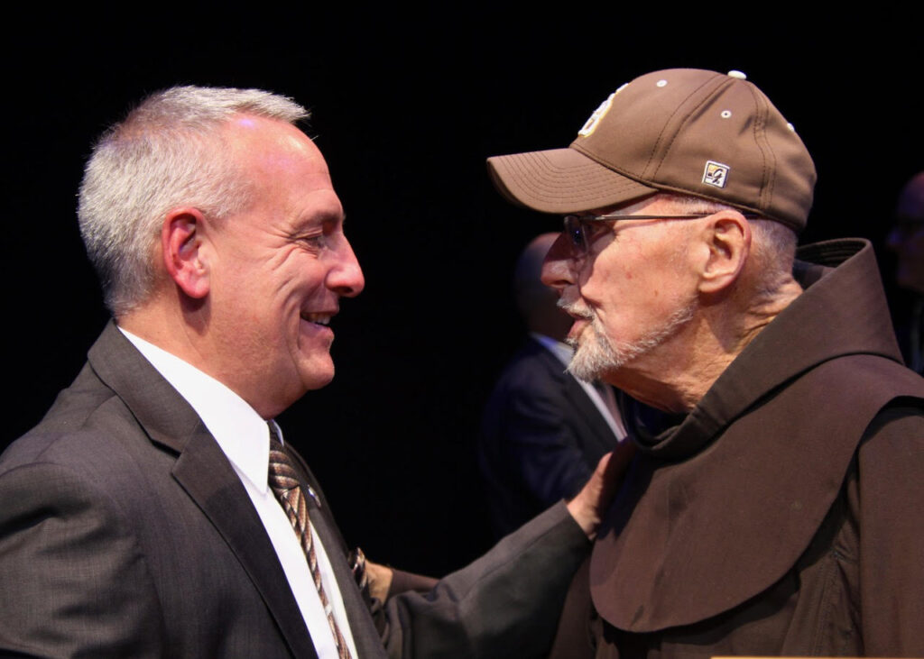 (Rick MIller/Olean Star)
Bob Beretta (left), the new vice president and director of Intercollegiate Athletics at St. Bonaventure University, speaks Friday with Fr. Dan Riley, OFM, the St. Bonaventure priest who founded the Warming House in Olean, the nation’s oldest student-run soup kitchen and Mr. Irenaeus , the Allegany County retreat.