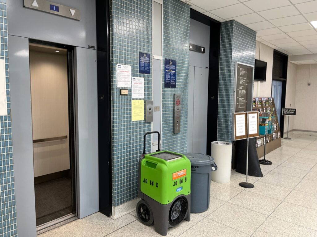 
(Rick Miller/Olean Star)  A dehumidifier/fan was located between elevator door on the first floor of the Cattaraugus County Center Wednesday after a water leak Tuesday closed the building until Monday.