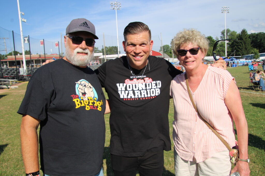 (Rick Miller/Olean Star) Southern Tier Wounded Warriors Concert host Col. Patrick Miller (center) poses for a photo with two friends, Gary Nease (left) and Barb O’Brien, at Bradner Stadium Saturday.
