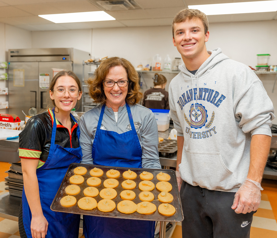 (St. Bonaventure photo) Betsy Gingerich, wife of university President Jeff Gingerich, stands with two student volunteers at the Warming House, where she is a volunteer. She is chairman of a Sept. 26 fundraiser for the Warming House.