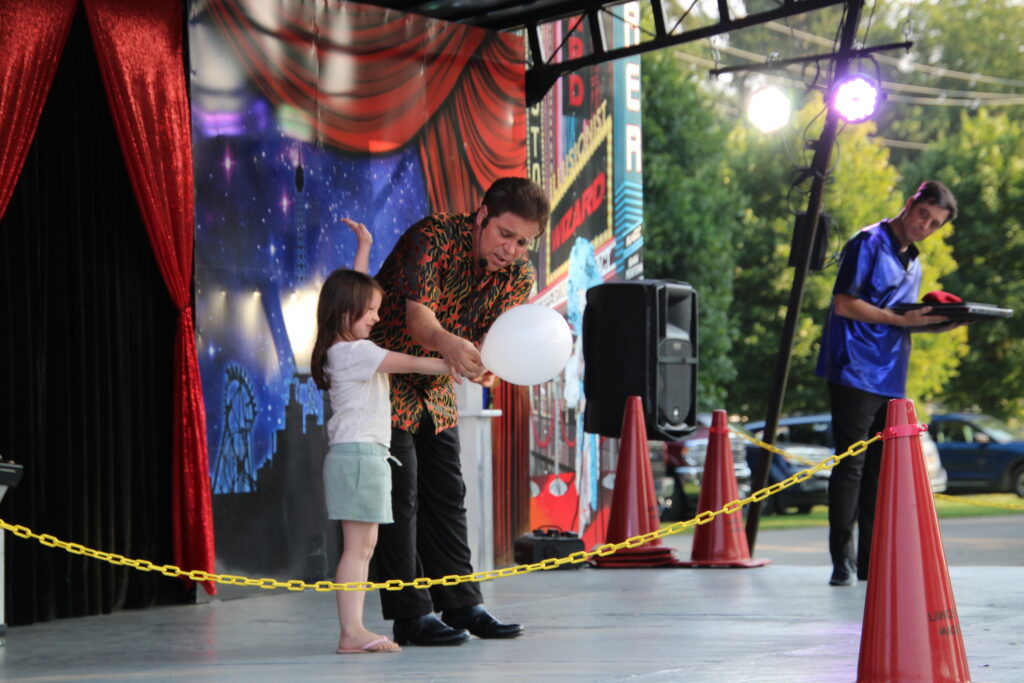 (Rick Miller/Olean Star) Magician Lance Gifford gets help from a young member of the audience for his magic show at the Cattaraugus County Fairgrounds.