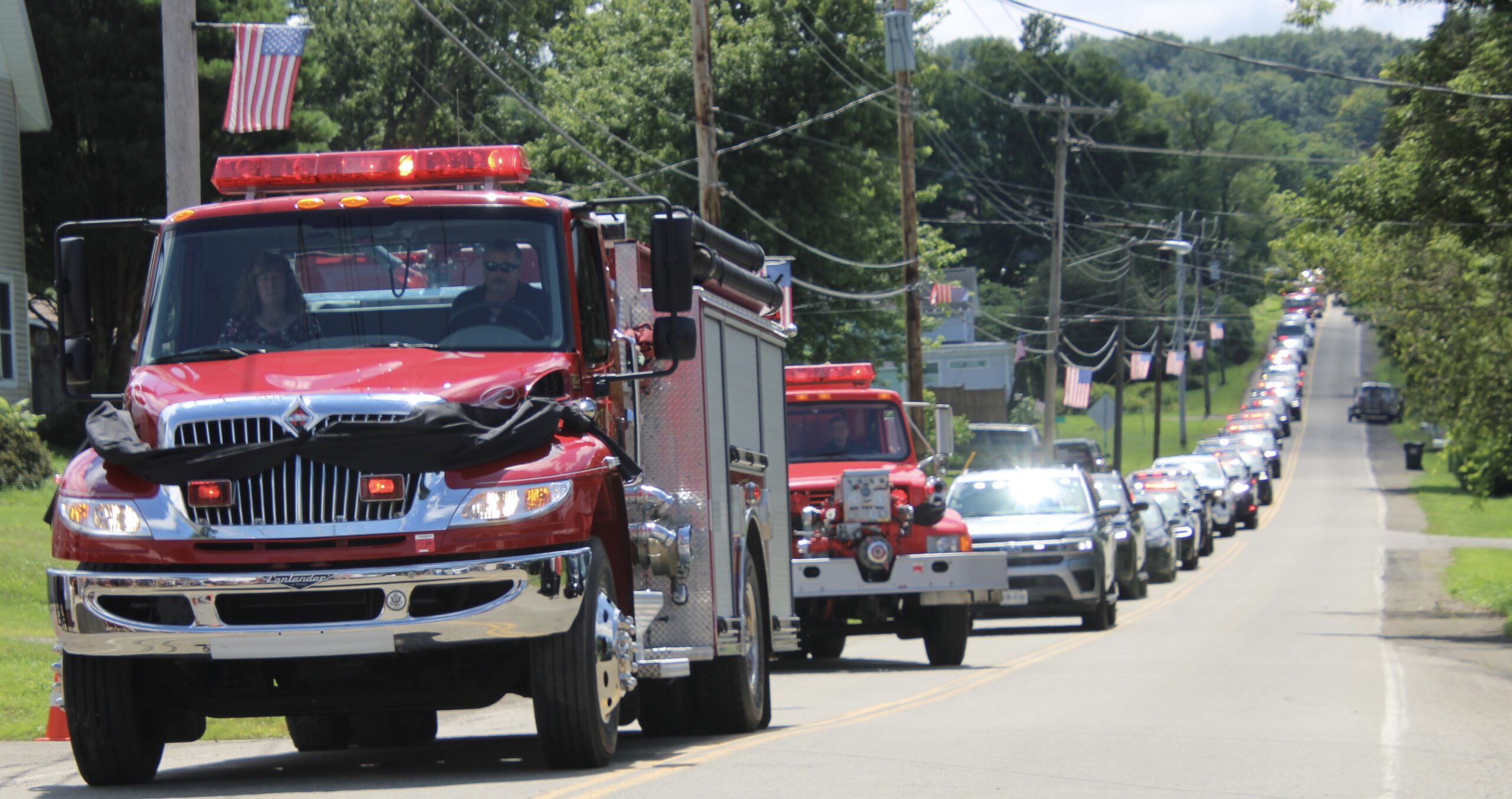 (Rick Miller/Olean Star) The front of an East Otto fire truck is draped in a black bunting Wednesday in memory of Tim Lexer, a beloved local firefighter and former chief and a 911 dispatcher who died last week in an accident near his home. Police and fire vehicles escorted the hearse bearing Lexer's body from a funeral in Little Valley.