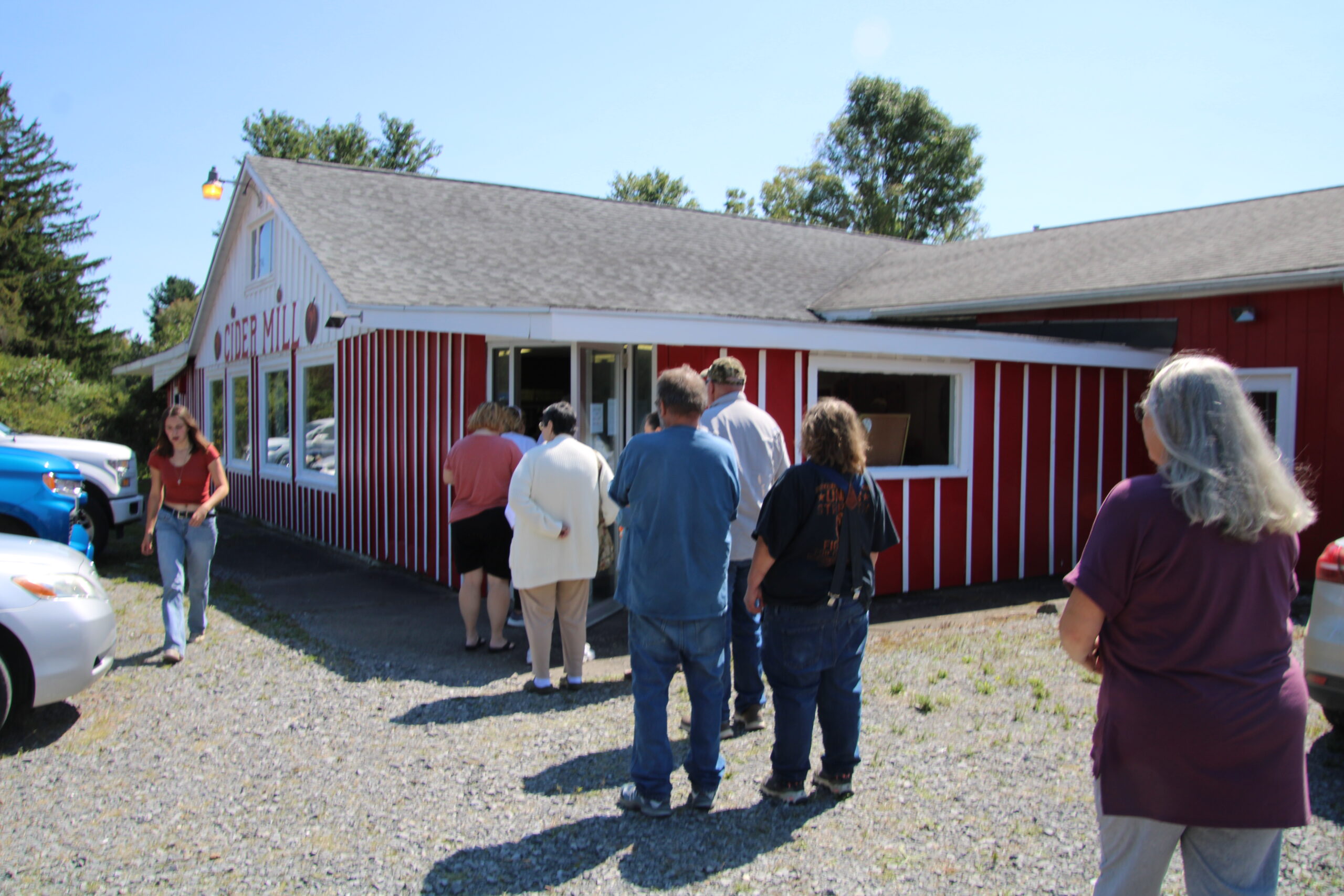 (Rick Miller/Olean Star) The line of customers stretched to the outside of Cummins Cider Mill when the iconic store reopened Wednesday after being closed for the past six years. The parking lot was full and cars parked on both sides of Route 417.
