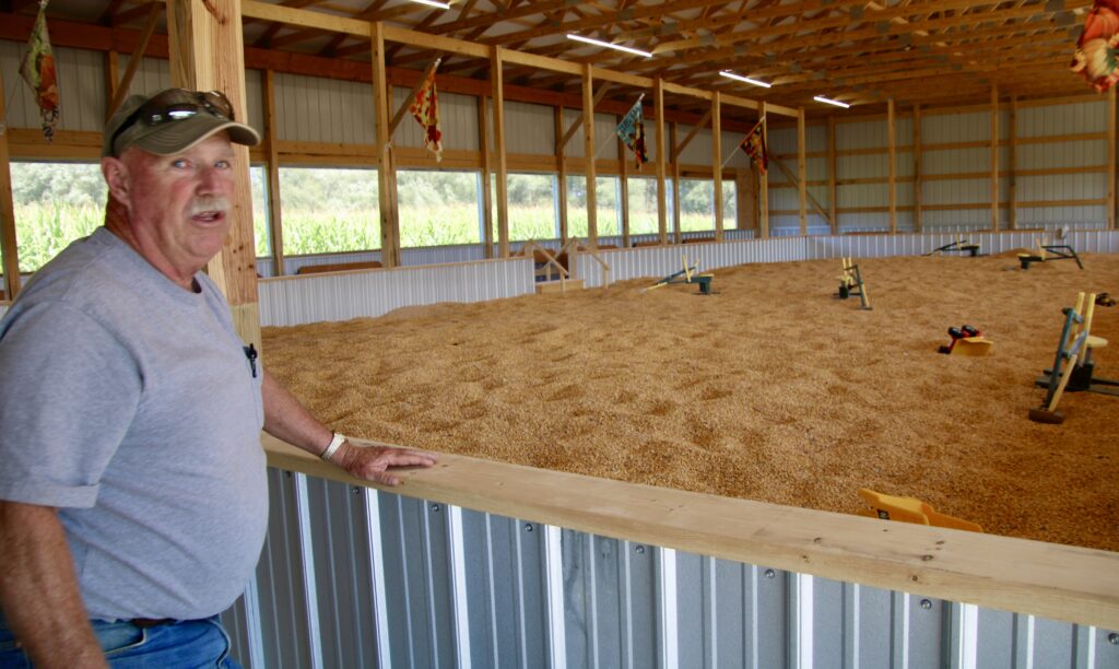 (Rick Miller/Olean Star) Dan Pawlowski stands next to Pumpkinville's biggest new attraction, the Corn Pit, where kids can move mountains of corn with the toys inside.