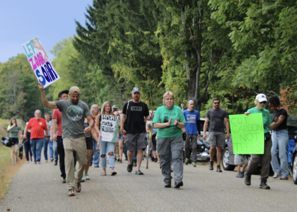 (Rick Miller/Olean Star) Demonstrators march down Wickham Road in Zoar Valley Saturday, where trees along the road in the town of Otto have been marked for cutting as part of a plan by state DEC and Audubon officials to clear-cut hundreds of acres to improve bird habitat.