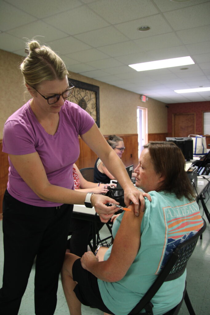 (Rick MIller/Olean Star) Health Department Registered Nurse Sidney Earley gives Karen Balcarczak of Limestone an influenza vaccine last week at a vaccination clinic at the Limestone Fire Department Community Center.