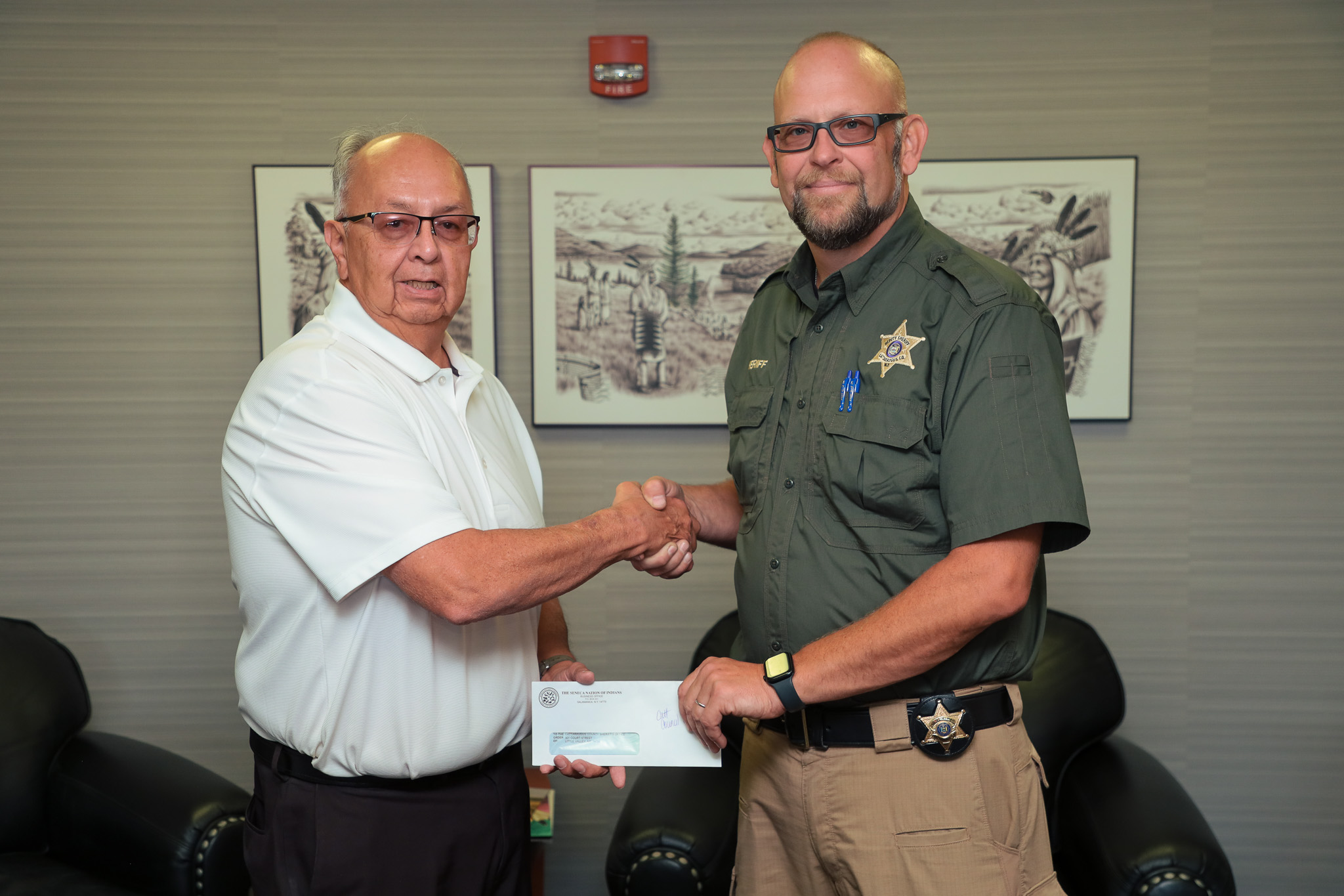 Seneca Nation President Rickey Armstrong Sr. (left), presents Cattaraugus County Sheriff with a $30,000 check to establish a new K-9 unit for the Sheriff's Department.  