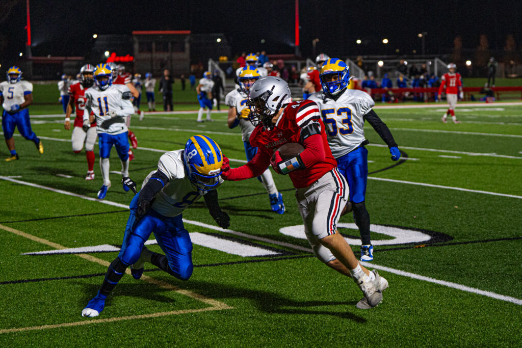 Zachary Trietley reaches out to stiff arm a Golden Eagles defender during Salamanca's blowout win in the Class C quarterfinals. | Photo by Hunter O. Lyle