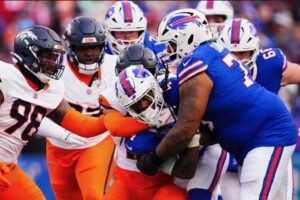 Cutline: Dion Dawkins carrying James Cook for extra yardage set the tone that the offensive line for the Bills was going to own the day after falling behind early. Photo by Angilo Allen/Buffalo Bills