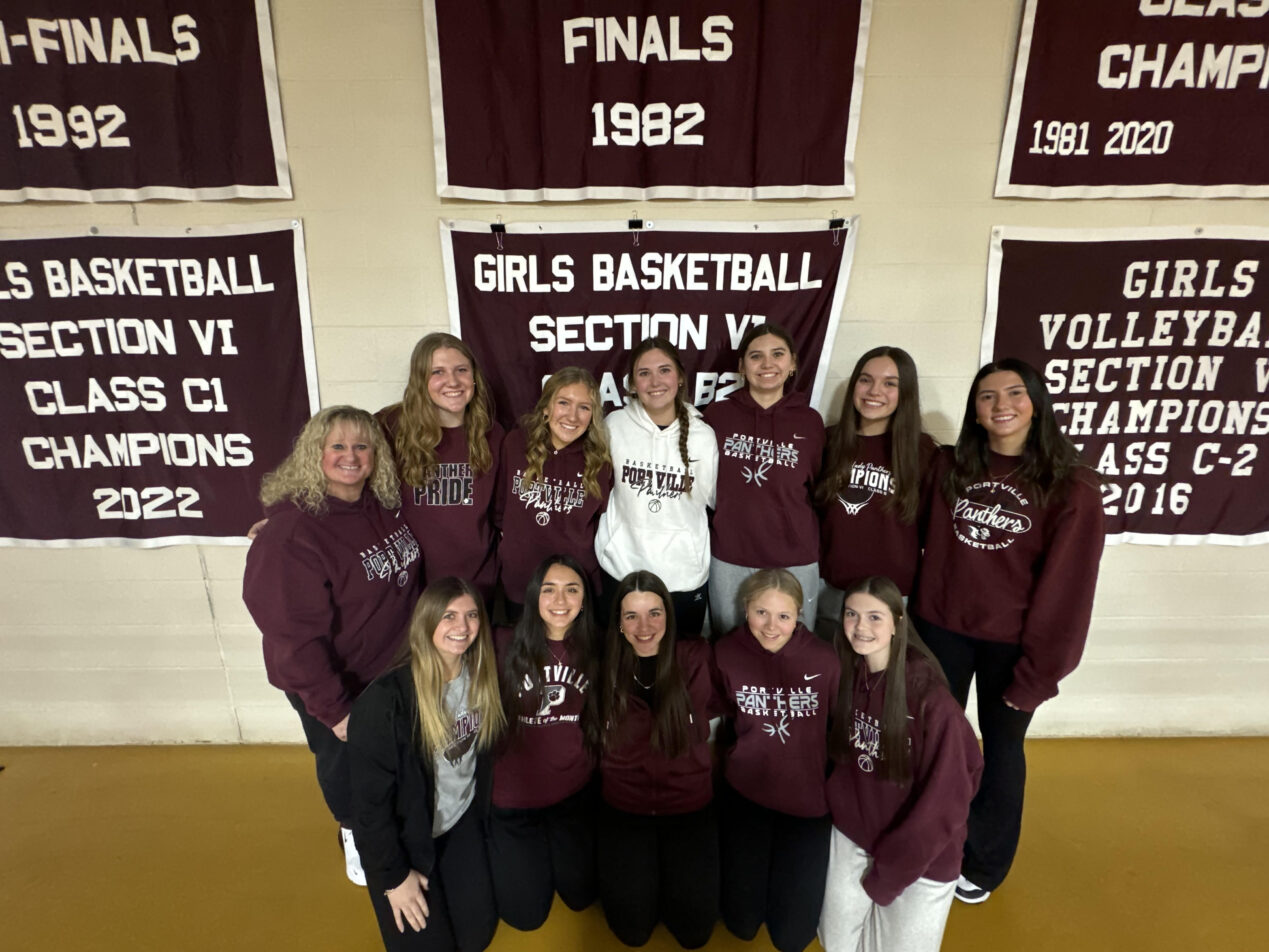 The Portville girls' basketball poses with their freshly revealed Section VI Championship banner. | Photo courtesy of Inga Welty