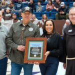 (St. Bonaventure photo) Captions: President Jeff Gingerich (left) presented Seneca President J. Conrad Seneca and First Lady Nicole Seneca with a framed print of the statement and a $1,000 donation to the Faithkeepers School. Fr. Stephen Mimnaugh, O.F.M., (right) read the Land Acknowledgment.