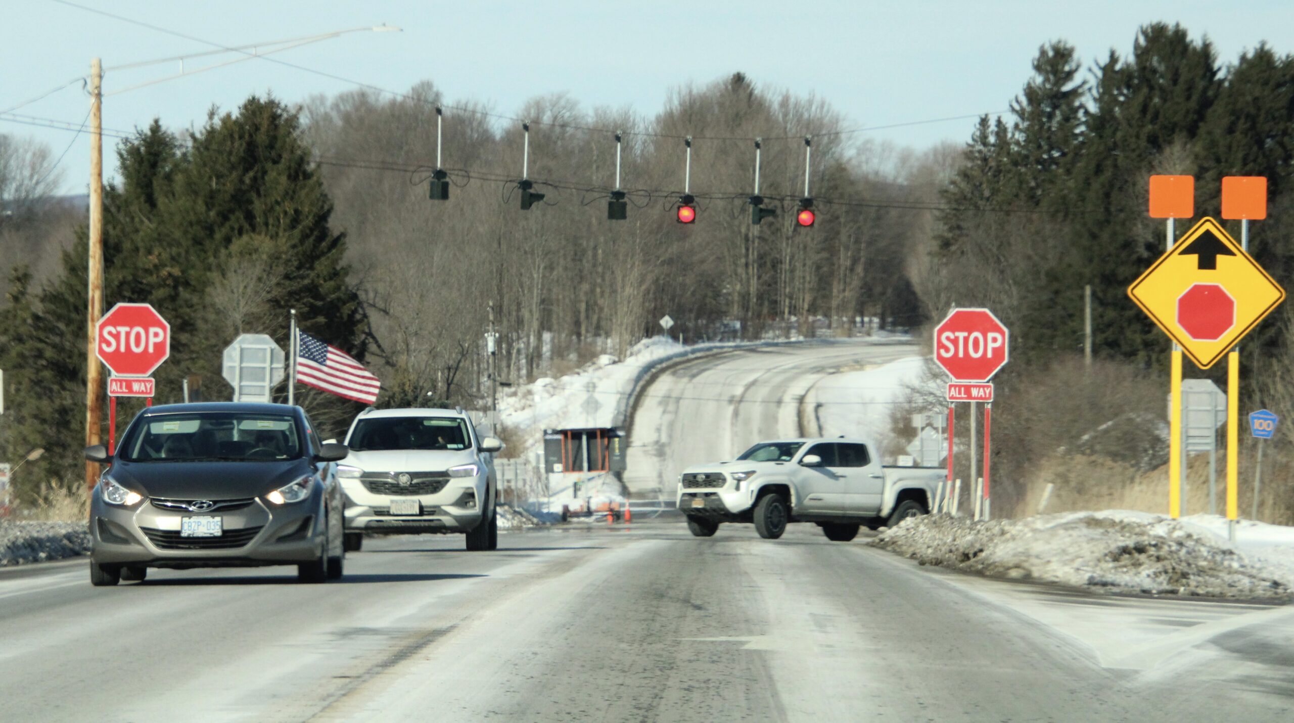 (Rick Miller/Olean Star) Traffic moves though the Peters Road intersection with Route 219 and Miller Road in the town of Ashford. The intersection, which now features all-way stop signs and red flashing lights, will make way for a roundabout at the site this summer.
