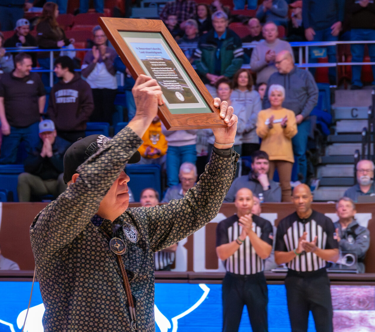 (St. Bonaventure photo) President J. Conrad Seneca holds up the framed print to the crowd at the Reilly Center on Sunday.