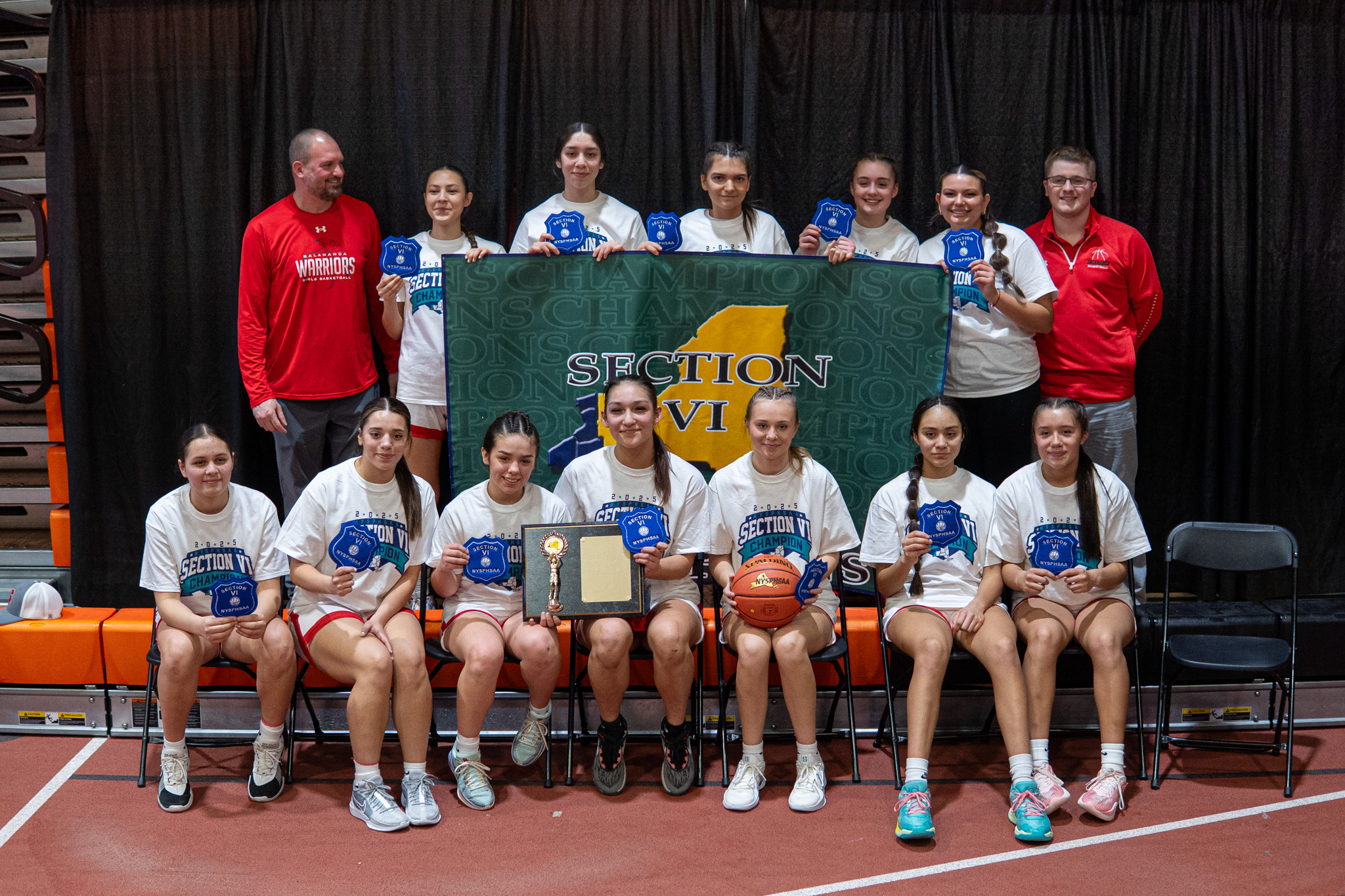 The Salamanca girls' basketball team poses with their trophy, patches and banner after defeating Wilson in the Section VI Class B2 championship. | Photo by Hunter O. Lyle